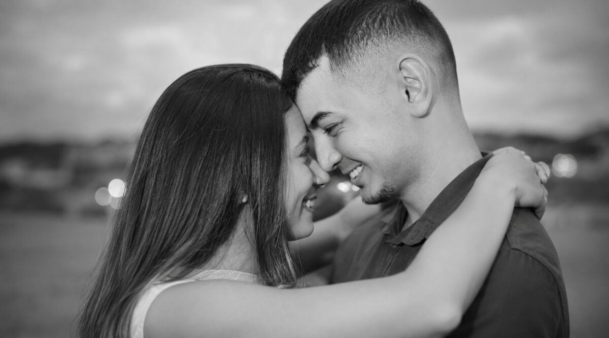 Danielle e Felipe de testas encostadas, abraçados ao fim da tarde